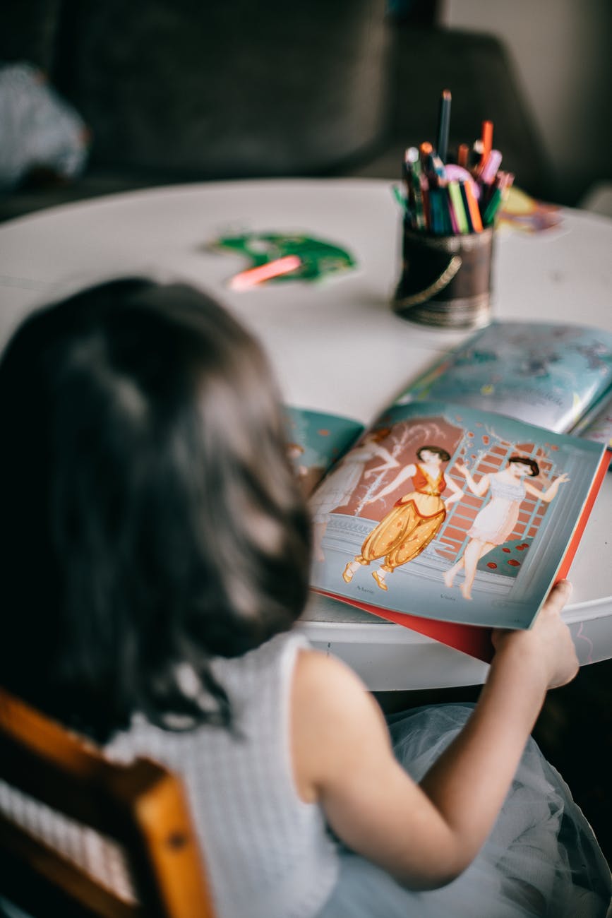 anonymous girl looking at picture in book